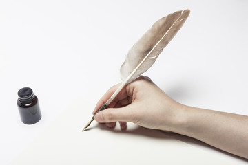 woman hand hold a fountain pen with ink on the white table.