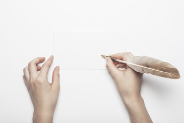 woman hand hold a fountain pen with letter on the white table.
