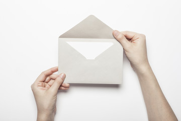 Fototapeta premium woman hand hold a envelope with post card on the white table.