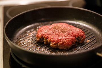 Ground meat patty in a frying pan