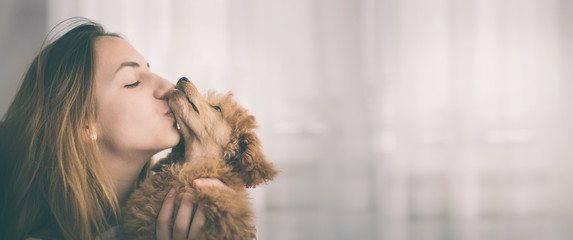 Young girl kissing her good friend dog . Background. - obrazy, fototapety, plakaty