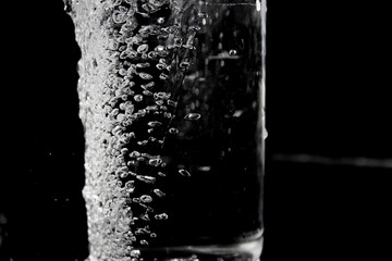 Obraz na płótnie Canvas Splash of water on black, Stylish water splash. Isolated on black background, bubbles in the glass,