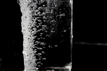 Splash of water on black, Stylish water splash. Isolated on black background, bubbles in the glass,