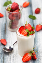 Homemade yogurt with strawberries on rustic table, selective focus