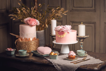 Luxury wedding table with a beautiful pink cake decorated with mastic and rose gold in antique classic interior