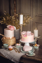 Luxury wedding table with a beautiful pink cake decorated with mastic and rose gold in antique classic interior