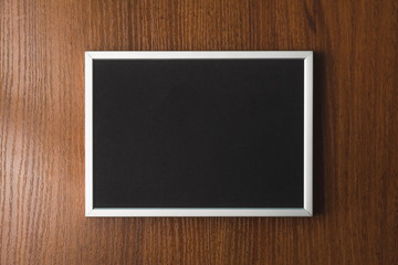 Black blackboard on wooden background