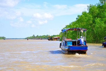 Fototapeta premium a sailor on a boat without passengers passing through an empty river in Asia. 