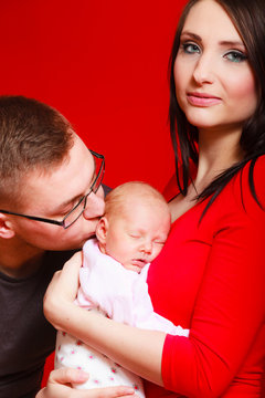 Newborn On Mother Chest Father Kissing Baby