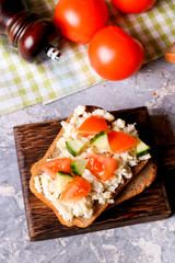 Breakfast with scrambled eggs and fresh vegetables on bread
