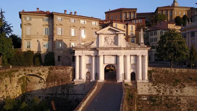 Bergamo - Old city. One of the beautiful city in Italy. Aerial footage of the old gate named Porta San Giacomo during the sunrise and a wonderful blu day