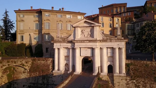 Bergamo - Old city. One of the beautiful city in Italy. Aerial footage of the old gate named Porta San Giacomo during the sunrise and a wonderful blu day
