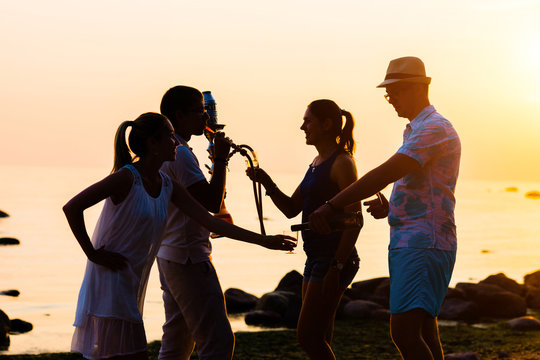 Man in hat enjoying a sunset on a beach and drinking a beer. Young, adult, freedom, beach, summer, concept.