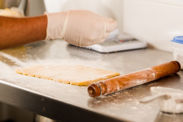 Bakery man preparing delicious christmas cookies in a bakery store and Sprinkle flour over the Dough