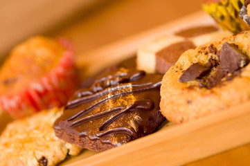 Freshly baked vanilla and chocolate chip cookies on wooden tray