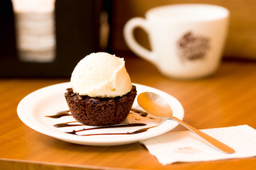 Delicious icecream on top of a brownie with a chocolate sauce in the plate