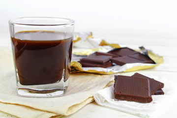 Chocolate cream and chocolate pieces on white background