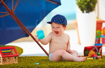 cute infant baby boy having fun outdoors at warm summer day