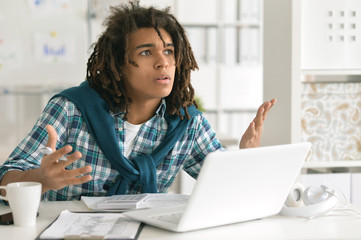 Fototapeta premium Portrait of a young business man with a laptop