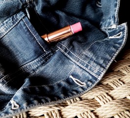 Pink lipstick in a pocket of a jean jacket