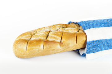 Fresh bread on white background wrapped in towel