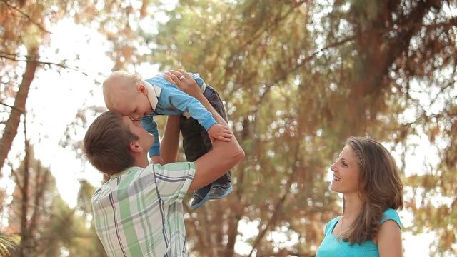 father lifts his son up in his arms