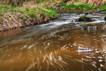 Small river, lines on surface, blurred water.