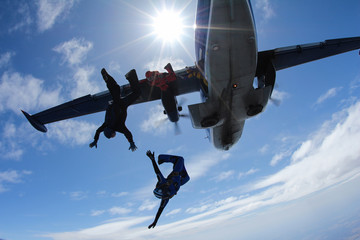 Fototapeta na wymiar Skydivers are jumping out of a plane