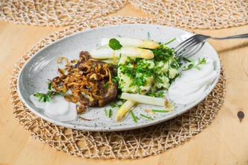 Roasted pork, asparagus, chives and radish on plate.