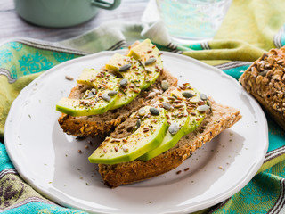 Avocado cereal sandwich for healthy snack with seeds on green napkin