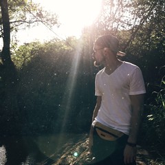 парень в лучах солнца в лесу