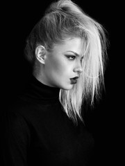 Blonde pretty girl profile portrait on black background, monochrome
