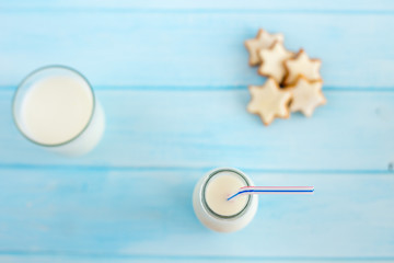 
Milk in a glass bottle on a blue wooden background. Dietary breakfast.