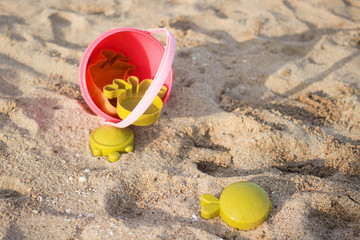 Fototapeta na wymiar Pink and green beach toys on the beach.