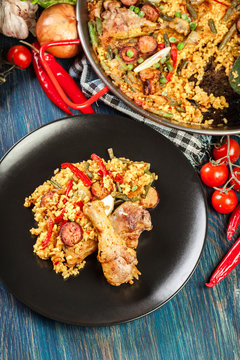 Traditional paella with chicken legs, sausage chorizo and vegeta