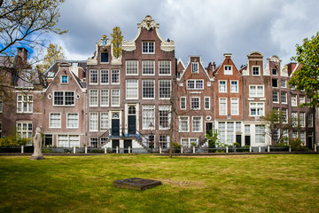 Fototapeta na wymiar Begijnhof houses and garden in Amsterdam, Netherlands. The Begijnhof is one of the oldest inner courts in the city of Amsterdam