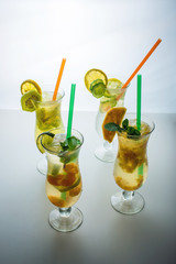 Set lemonade with ice in glass hurricane with tropical fruits