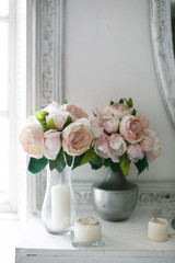 Peonies in a vase and with candles, stucco