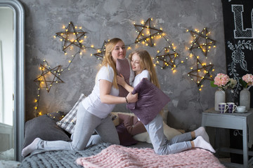 Fototapeta na wymiar Mom and daughter teen play together on bed