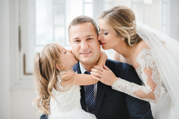 The bride with daughter embracing their father