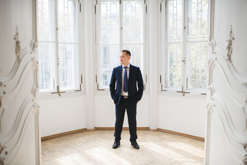 The handsome groom stands in the room