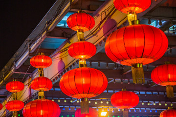 Chinese red lanterns hanging on historic building at night.