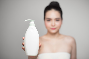 Obraz na płótnie Canvas Asian model holding shampoo