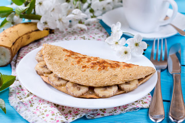 Pancake from oatmeal with banana and cheese on a wooden background, healthy breakfast