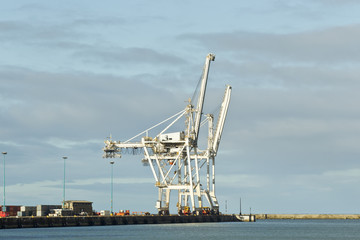 Fototapeta premium Large cranes on the wharf of a harbor
