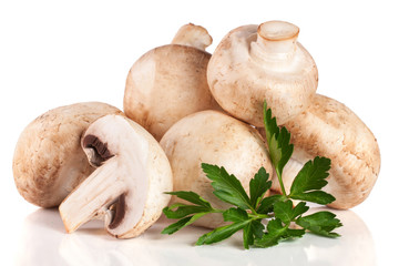 A bunch of champignon mushrooms with leaf parsley isolated on white background