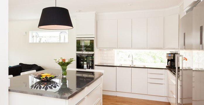 Fancy Kitchen Interior With Kitchen Island Countertop Of Black Marble