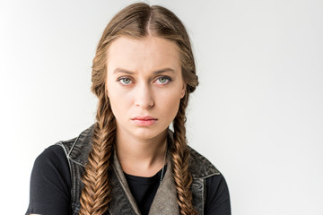 portrait of attractive rocker girl with braids looking at camera isolated on grey