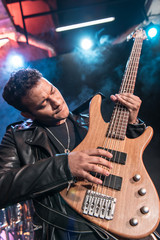 Obraz premium Electric guitar player playing hard rock music with bass guitar on stage