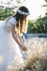 Attractive blond girl in forest dressed in communion